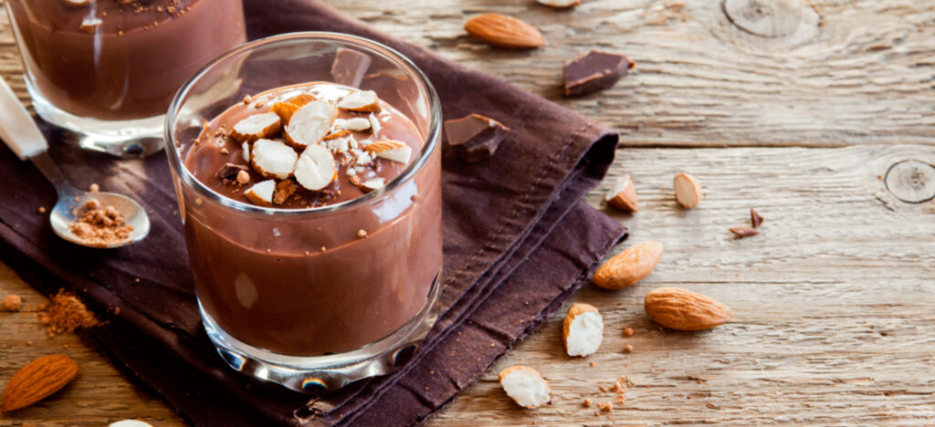 Merengue suiço sobre um doce de chocolate com raspas de nozes em taça